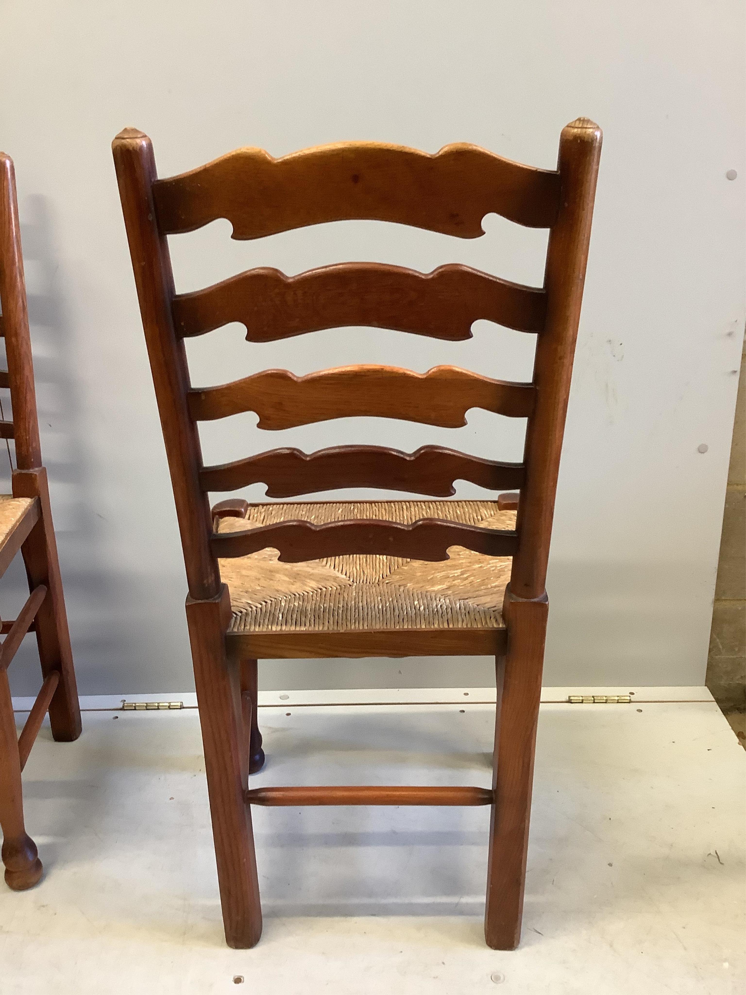 A 18th century style rectangular oak refectory dining table, width 183cm, depth 82cm, height 74cm and six rush seat ladderback chairs